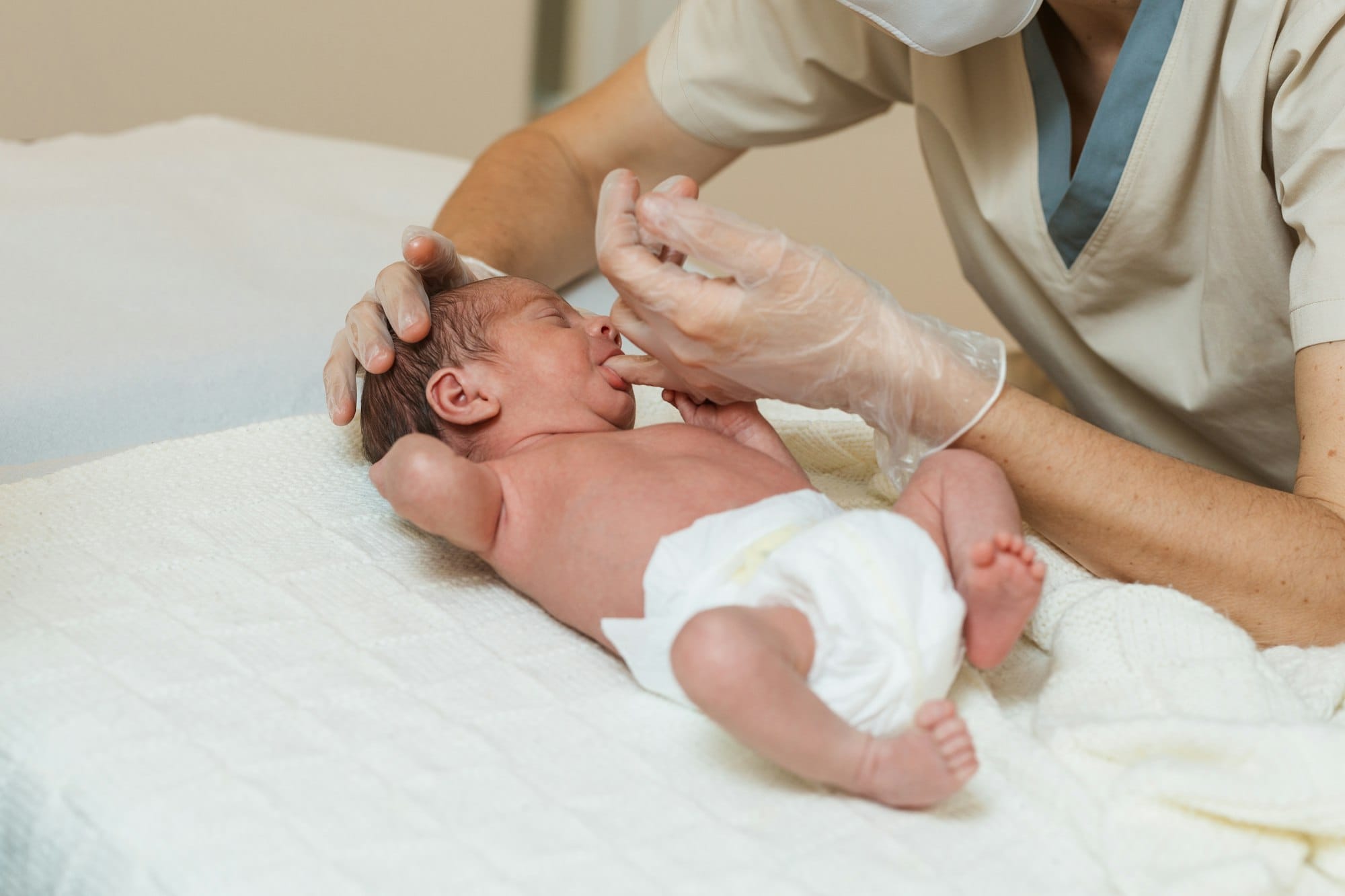 Professional physiotherapist performing a suction assessment in a newborn baby