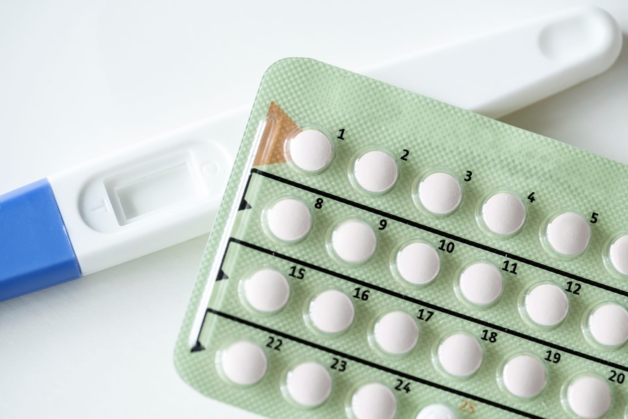 Closeup of pregnancy test and contraceptive pills birth control concept