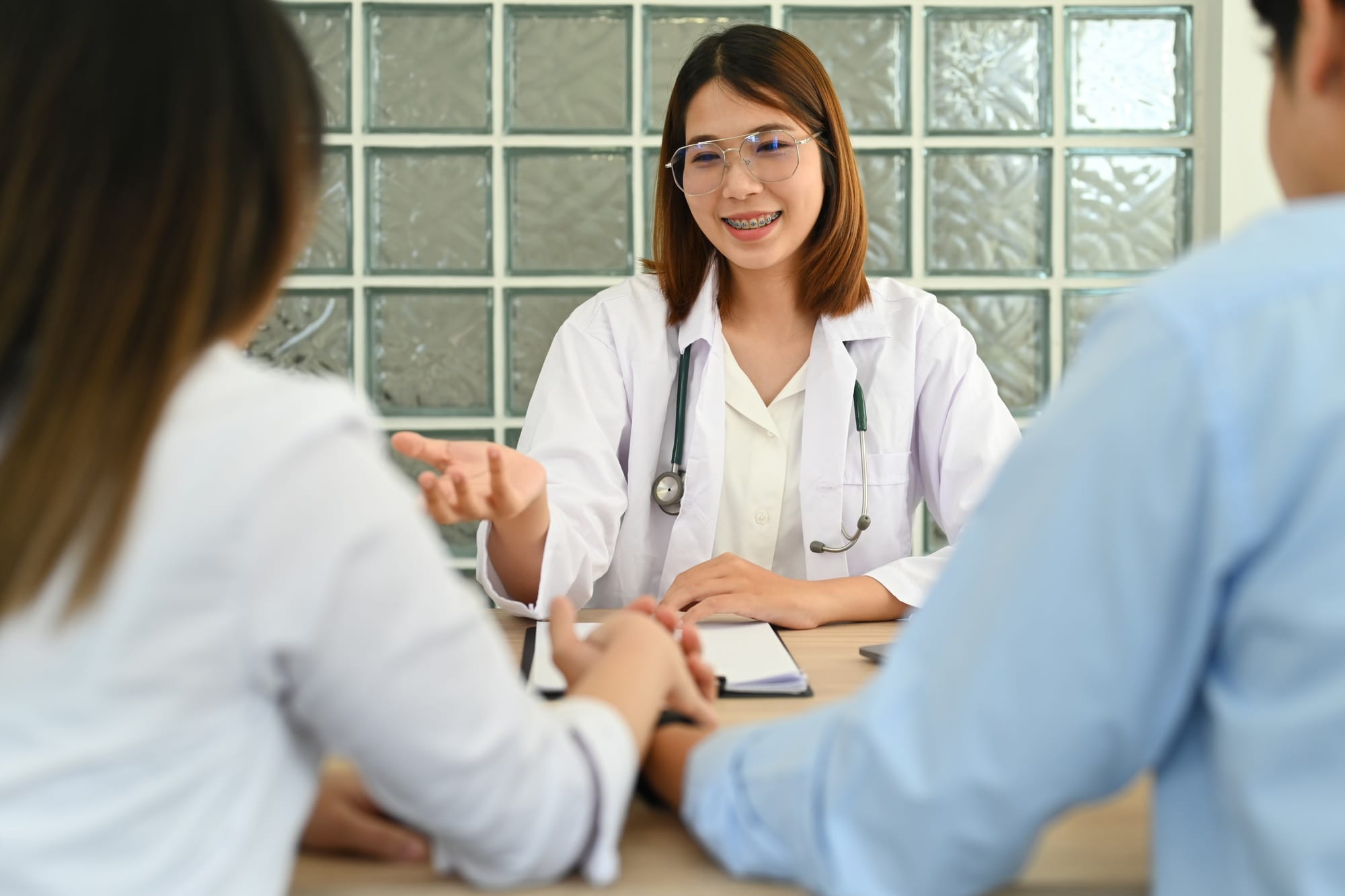 Gynecologist consultation with married couple during appointment at clinic. Family planning concept.