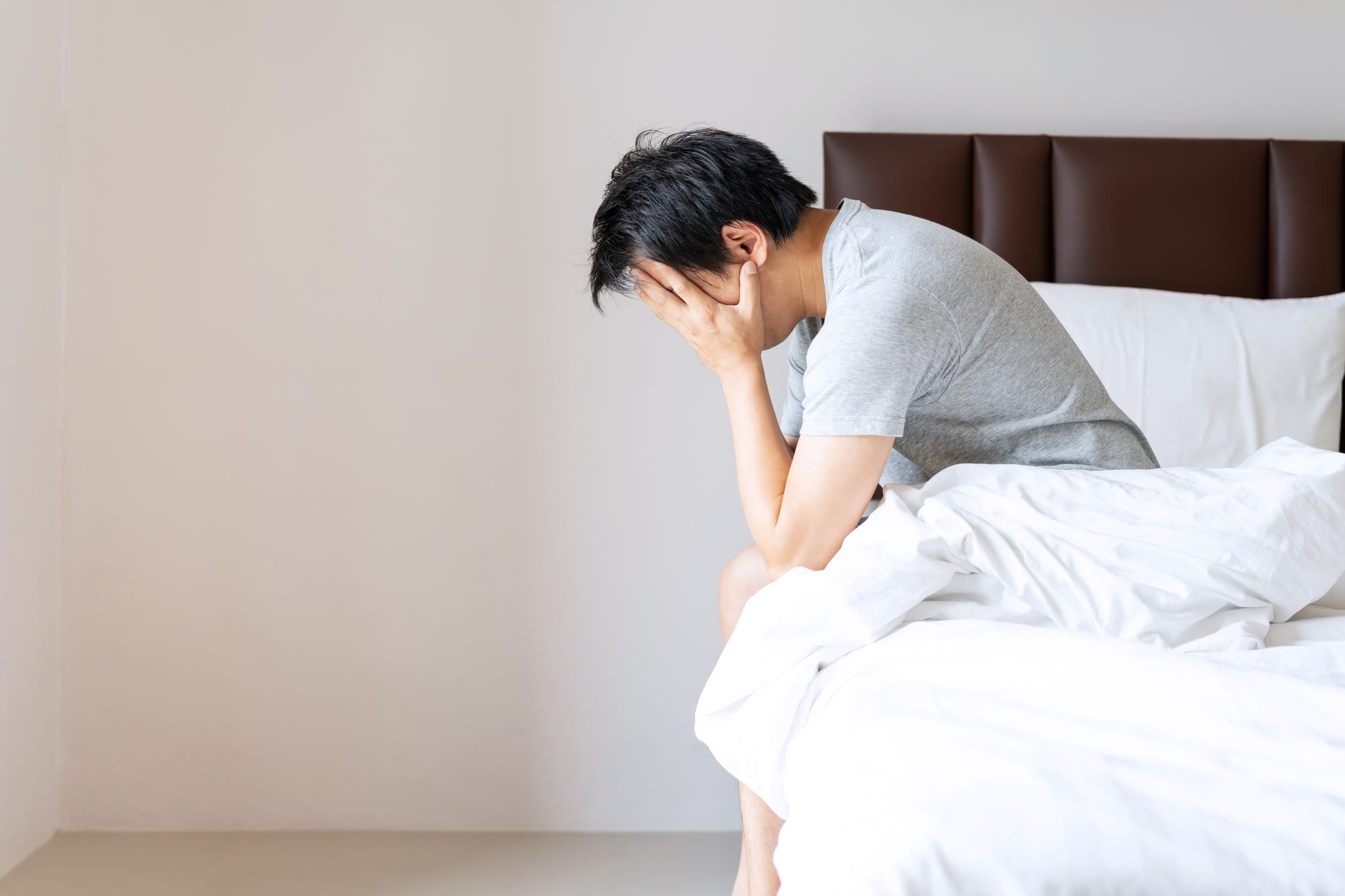 Lonely young man depressed and stressed sitting in the bedroom