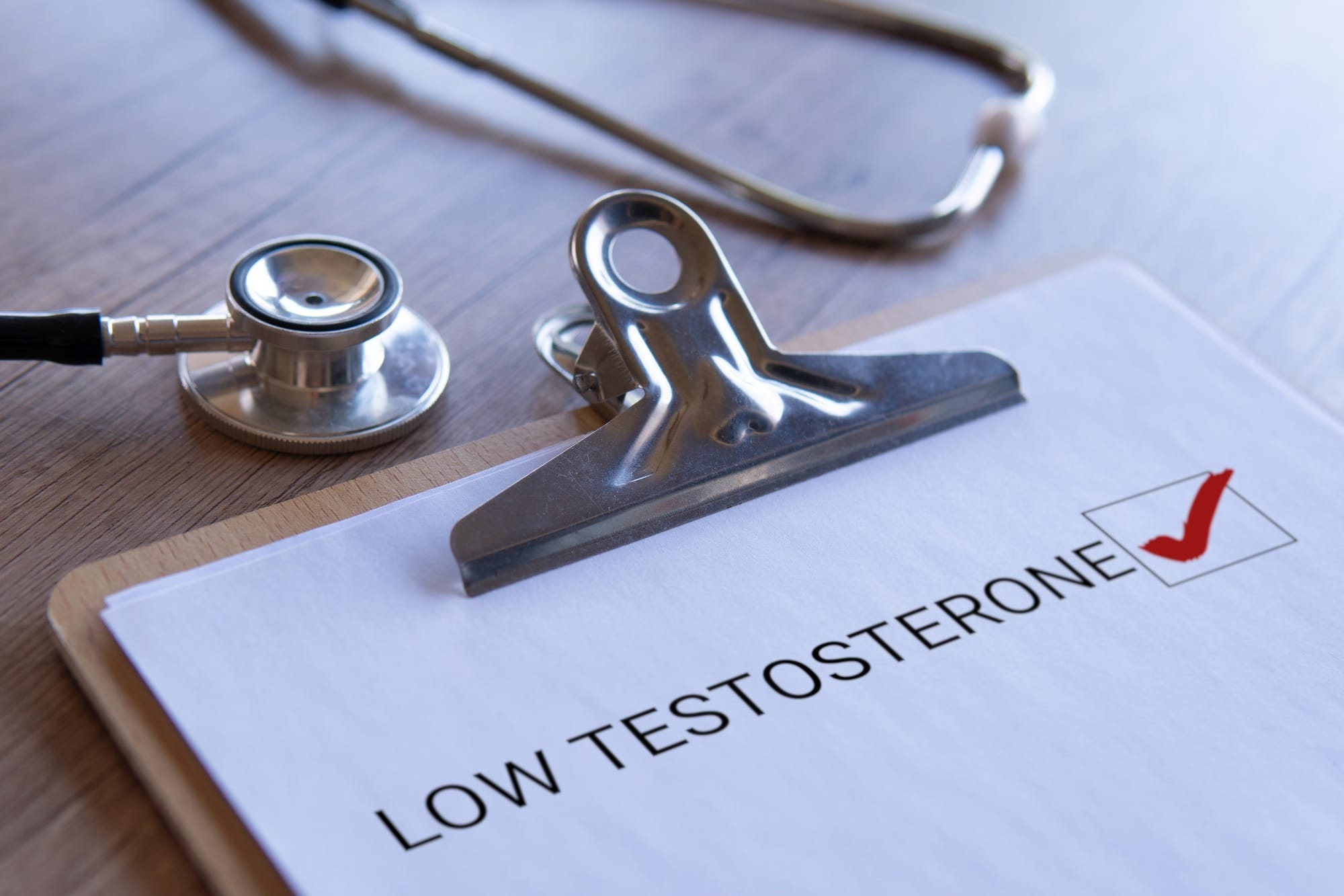 Stethoscope and clipboard with text 'Low Testosterone'.